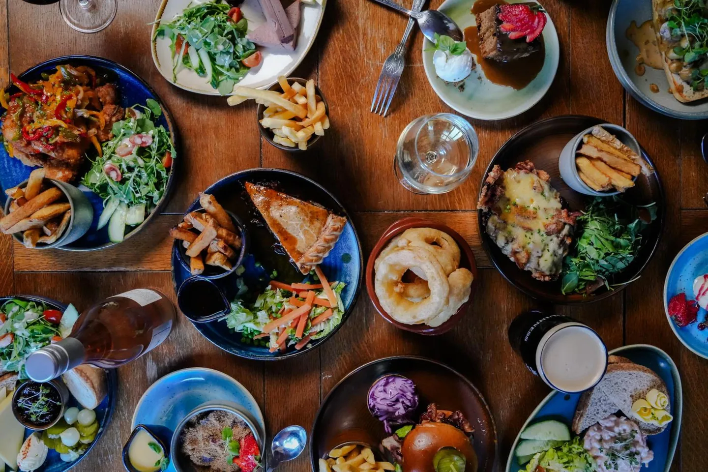 A table of dishes at the Mayflower seen from above — pies, salads, onion rings, a cheeseboard and puddings